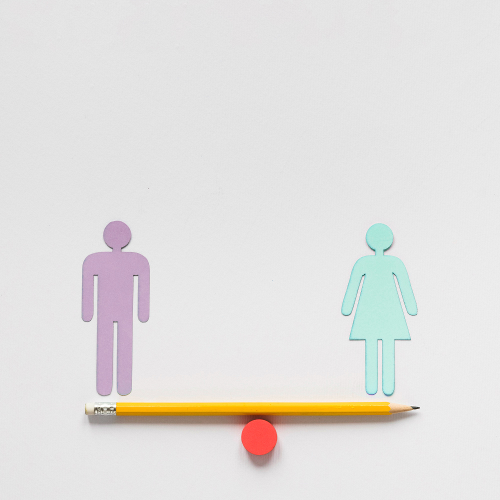 Grupo diverso de personas colaborando en una mesa de trabajo, con iconos de igualdad o símbolos de equilibrio, representando inclusión y oportunidades. Título: Igualdad de oportunidades